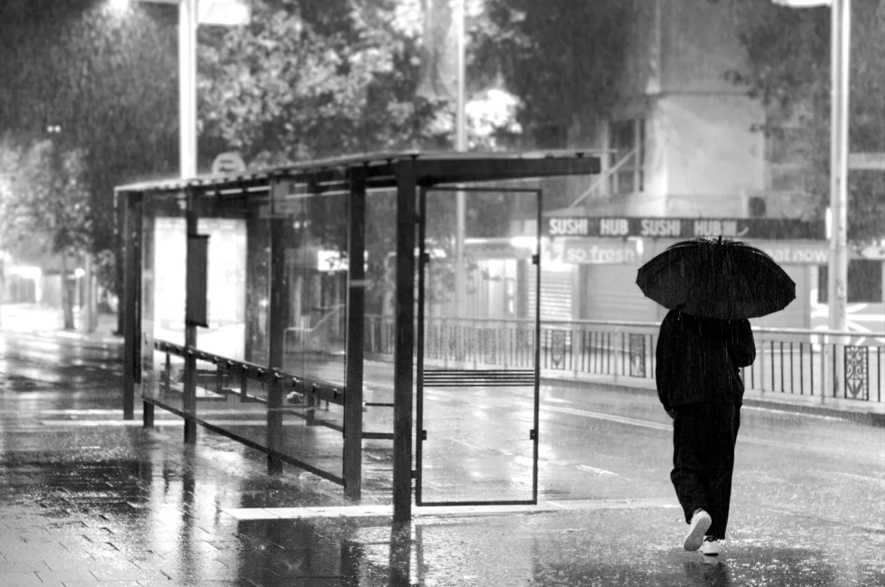 Resonance with a minimum depth of field of man in black, walking in the rain